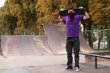 Stylish man with skateboard in skate park. Space for text © New Africa
