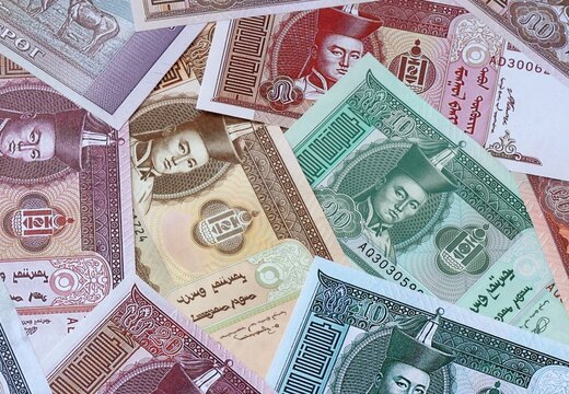 Mongolian tugrik money bills in pile. Big amount of Mongolia MNT currency cash close up