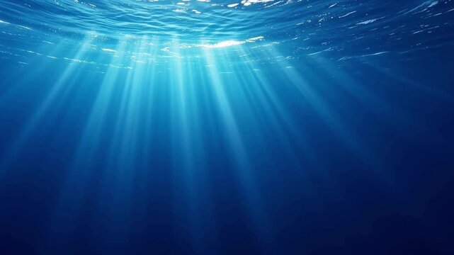 Sunbeams shining through underwater surface into deep blue ocean water, serene aquatic nature background