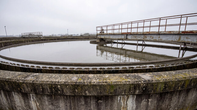 Circular clarifier tank with a rotating scraper bridge at a municipal water treatment plant