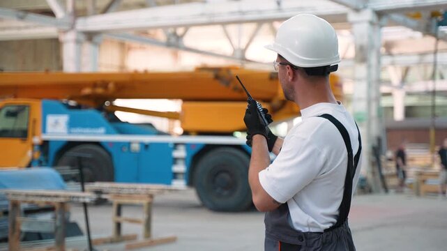 Construction site foreman giving instructions with walkie talkie