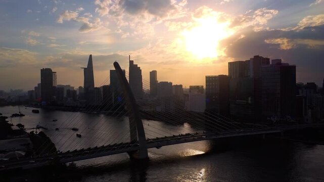 Ba Son Cable Stayed Bridge & Saigon River Skyline Silhouetted by Golden Sunset in Ho Chi Minh City 4K Drone Aerial View