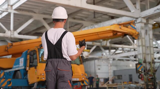 Construction foreman giving instructions to crane operator