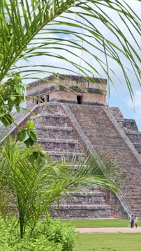 Kukulkan pyramid at Chichen Itza through palm leaves