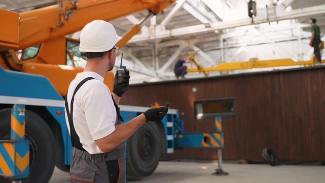 Construction foreman operating loading of a modular house