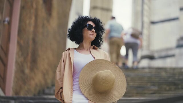 Stylish woman walks in front of Siena Duomo Cathedral staircase in Tuscany, Italy