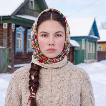 A portrait of a beautiful young brunette woman in a rustic Russian style