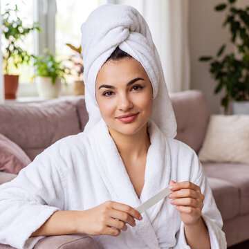 A beautiful young woman in a white terry dressing gown and with a towel on her head