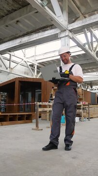 Construction worker using laptop in prefabricated house factory