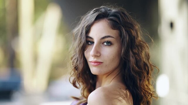 Portrait of a thoughtful sensitive woman with wavy hair look at camera with provocative expression, slow motion
