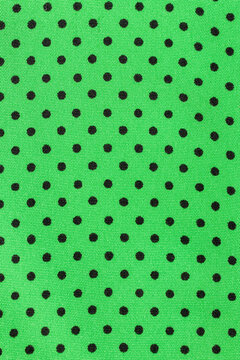 Green fabric texture with black polka dot pattern