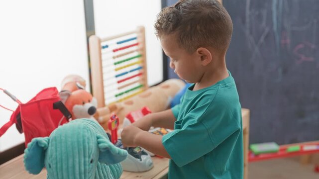 Boy inserting a toy card into a play cash register with hands visible, abacus and stuffed toys on table, in building; concentration learning play.