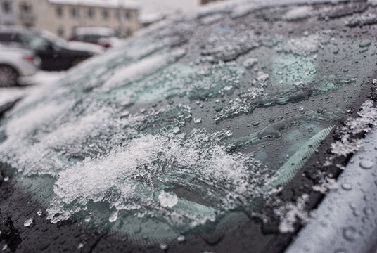 Melting Snow and Water Droplets on Car Windshield in Winter Morning