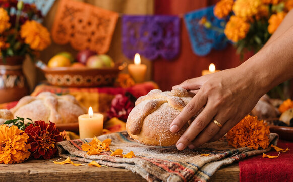 Person holding pan de muerto for Day of the Dead celebration ofrenda altar