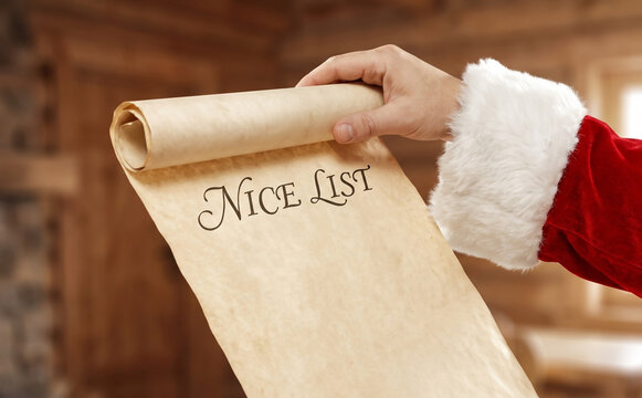 Santa Claus holding a rolled parchment paper scroll with Nice List heading for Christmas concepts