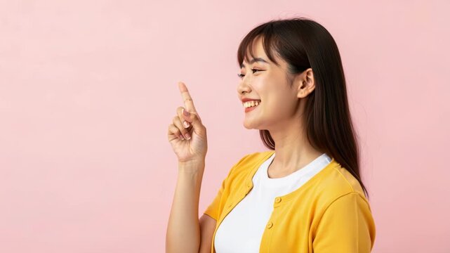 A Young Asian Woman Points Upward with a Smile