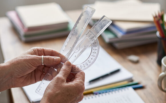 Senior woman holding geometry tools and rulers for studying and math education in classroom