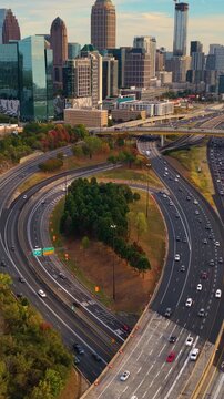 Urban Atlanta cityscape with modern skyscraper buildings and driving traffic on elevated interstate highways. American transportation system and metropolitan mobility.