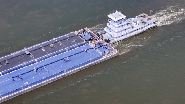 tugboat navigating South down the Mississippi river pushing a set of liquid cargo barges