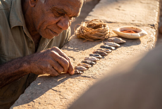 Mancala Game Played by Elderly Man in Warm Sunset Light Outdoors