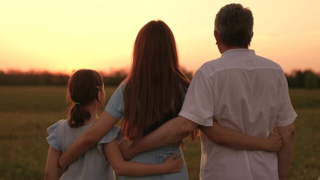 Happy family, father mother child hugging sunset, girl hugging parents man woman sunset, people outdoors nature, countryside family love, tender evening light, tender countryside moment, heartfelt