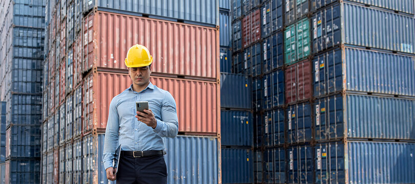 Asian Male Logistics Worker Using Smartphone in Shipping Container Yard, Global Cargo Transportation and Import Export Business