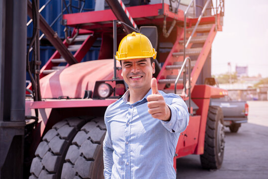 Happy Construction Worker Giving Thumbs Up Wearing Yellow Safety Helmet at Industrial Worksite