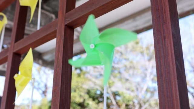 Green pinwheel spinning quickly in the wind
