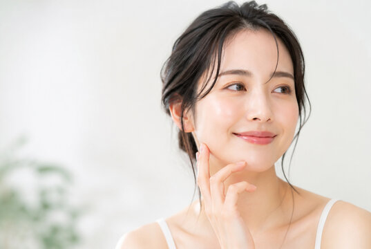 スキンケアをする笑顔の日本人女性のポートレート