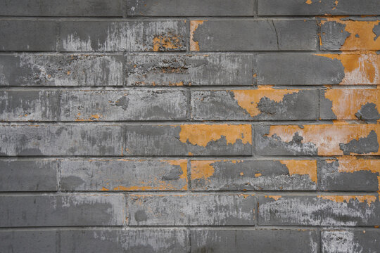 Old Gray Brick Wall with Peeling Yellow Paint