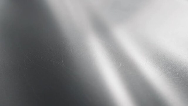 Silver metal surface texture with soft highlights, gentle reflections, and smooth monochromatic gradients