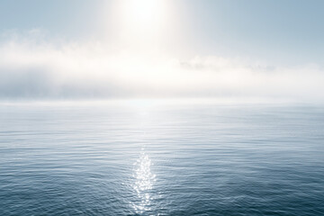 Obraz premium Misty morning sea with bright soft light and gentle morning sun reflection
