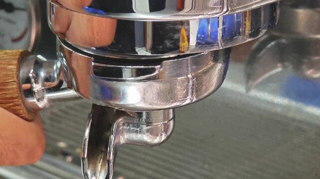 Locking a portafilter with a wooden handle into an espresso machine grouphead.