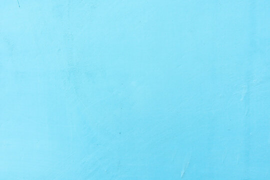 Sky blue cement wall texture background. Uneven grunge stucco baby blue painted concrete wall surface. Grungy weathered abstract background. Vintage 