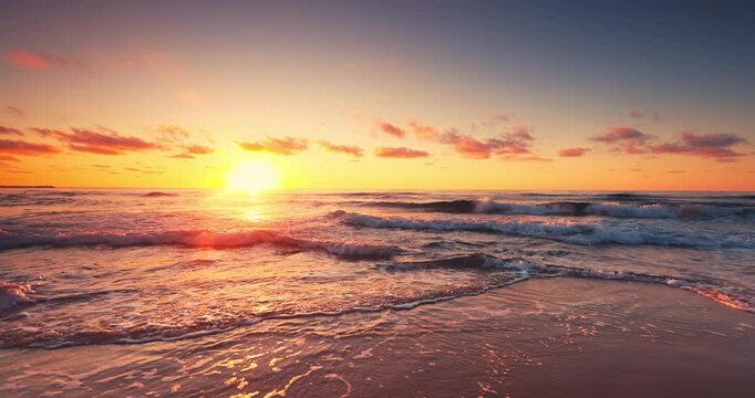 Golden Sunrise Over Calm Ocean Beach Shore With Gentle Waves Splashing on the Reflective Wet Sand and Sea Horizon