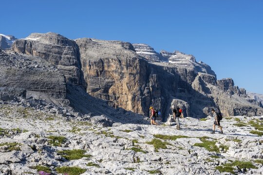Three mountaineers on a hiking trail on the Grost&eacute; Plateau, Brenta Mountains, Parco Naturale Brenta-Adamello, Trentino, Italy