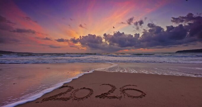 2026 Year text Written In Sand On Beach At Colorful Sunrise Over Ocean Waves