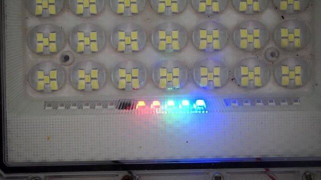 Close-up shot of an array of LED floodlight diodes featuring an active glowing color indicator.