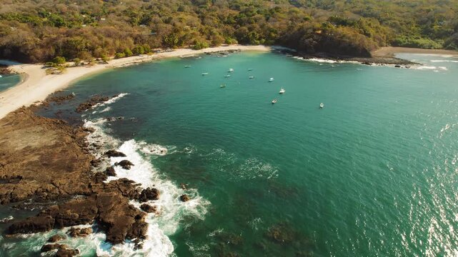 Aerial of turquoise bay with San Juanillo beach and boats anchored offshore