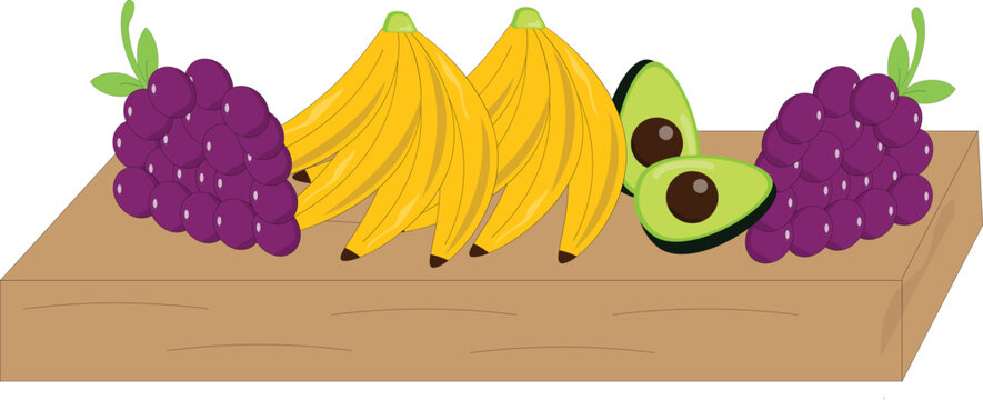 Fresh assorted fruits including purple grapes, yellow bananas, and sliced green avocado beautifully arranged on a rustic wooden cutting board