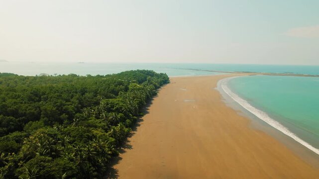 Flock of pelicans flying over famous Whale Tail sandbar formation at Marino Ballena National Park beach in Costa Rica