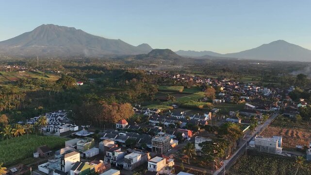 Aerial view of residential housing area in rural countryside with mountain landscape at sunrise