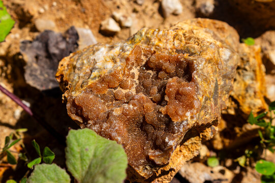 Sparkling quartz druzy encrusted with brown chalcedony on raw flint rock, captured in a natural quarry setting highlighting intricate crystal formations and earthy mineral textures