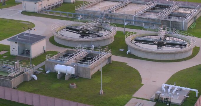 Aerial motion of a modern sewage treatment plant featuring several clarifiers, aeration basins, and various filtration processes.
