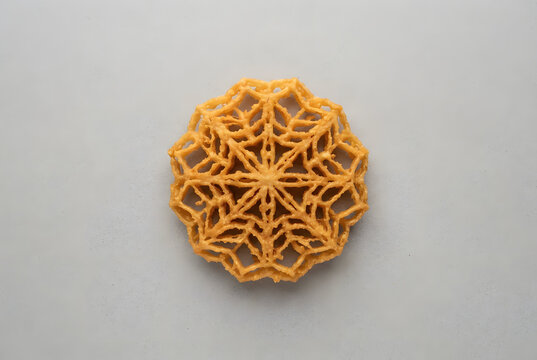 &bull;	Traditional crispy Kokis (lace cookie) top view on a clean background