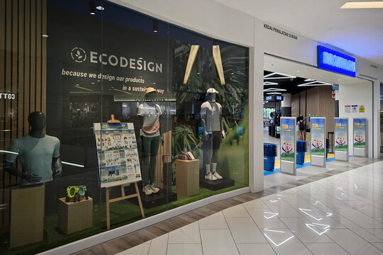 Penang, Malaysia - Jul 26, 2026: Exterior glass display showcasing sportswear mannequins with Ecodesign branding next to the entrance of a Decathlon retail store inside a shopping mall.