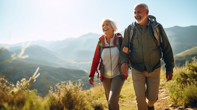 senior couple hiking adventure on mountain top. happy smiling active elder generation exploring scenic landscape. enjoying sunny day. wearing backpacks.