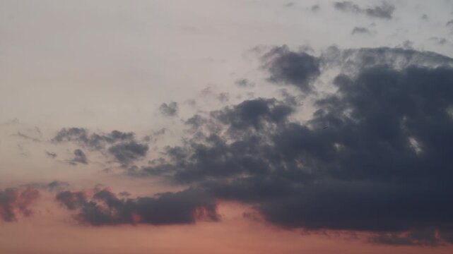 Dramatic sunset sky with dark clouds and warm brown atmospheric tones.