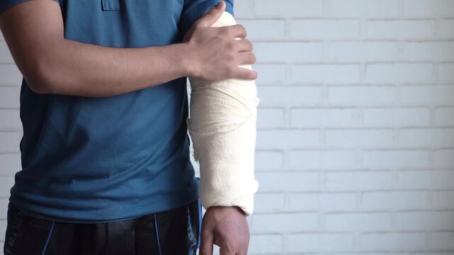 Person applying bandage to injured arm with medical wrap for support and healing