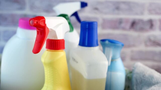 Various cleaning supplies arranged on a surface with a brick wall background